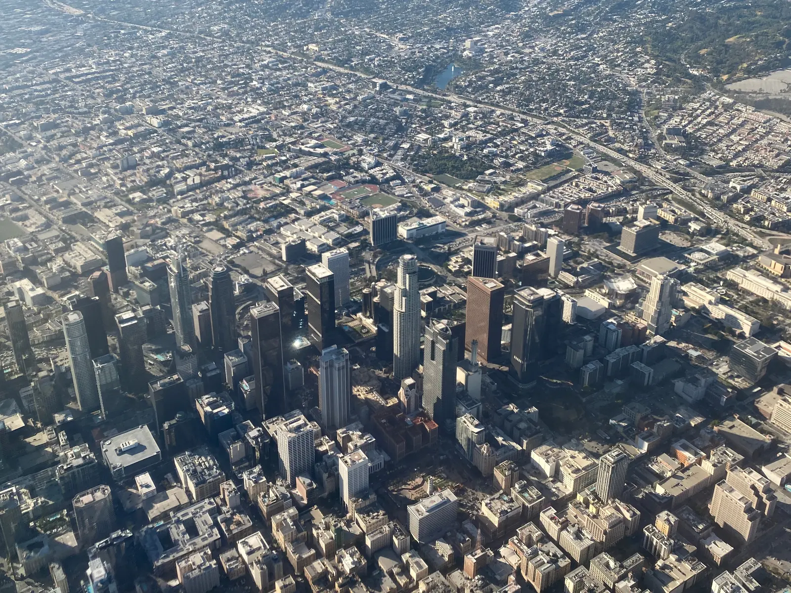 Downtown Los Angeles towers from a plane window, with Echo Park beyond